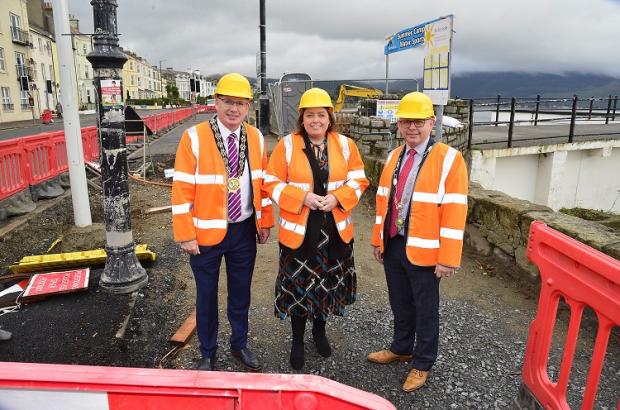 Communities Minister Deirdre Hargey is pictured with Newry Mourne & Down Council Chair Michael Savage (L) & President of Warrenpoint Burren & Rostrevor Chamber of Commerce Mark Kelly (R) on a visit to Warrenpoint point to view progress on a £2.6m scheme