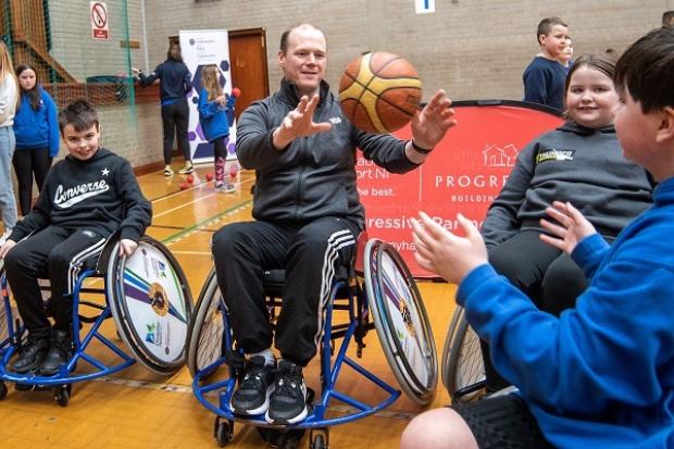 Photo of Minister playing wheelchair baskrtball with children