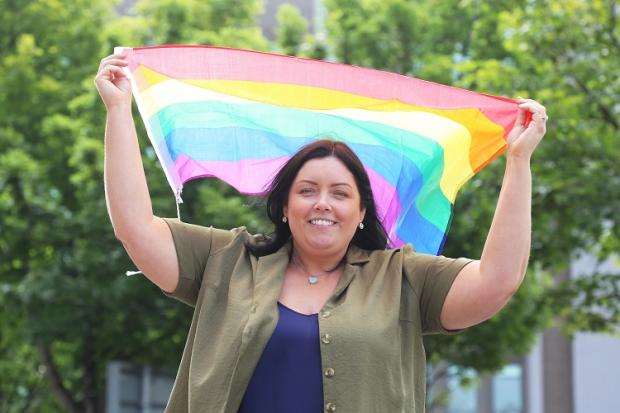Minister Hargey holding Pride flag