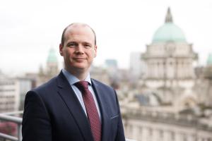 Communities Minister Gordon Lyons pictured in front of the dome at the top of Belfast City Hall
