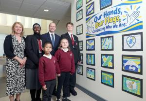 A man and a woman stand with a group of four children in school uniforms. Two children appear to be teenagers and the other two are younger children