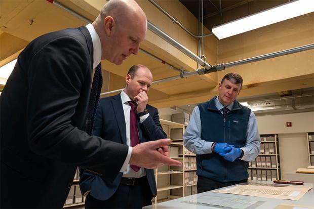 Minister Gordon Lyons (centre) pictured in the National Archives in Washington, DC, looking at artifacts with U.S. Consul General in Belfast James Applegate (left) and archivist Trevor (right)
