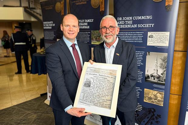 Minister Lyons holding an old Belfast Newsletter print